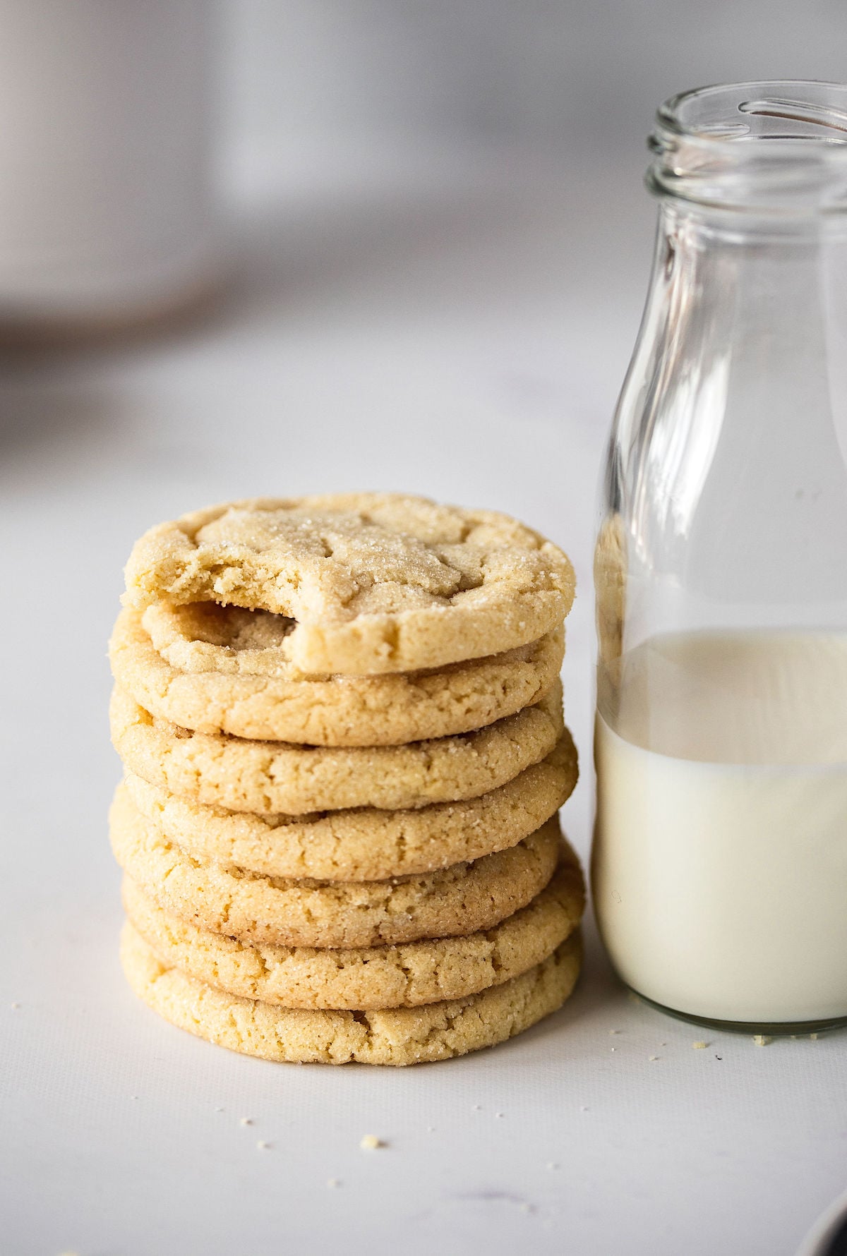 stack of soft and chewy sugar cookies with a bottle of milk.